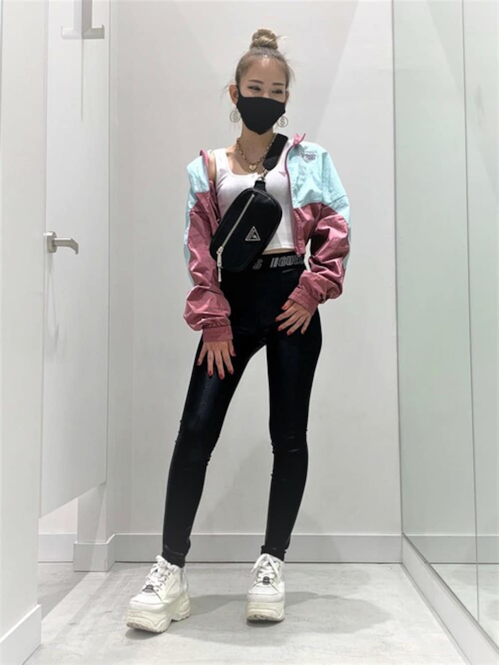 ホワイト系のタンクトップ、グリーン系のナイロンジャケット、ブラック系のボディバッグ/ウエストポーチを着用したレディースの秋コーディネートの1枚目の写真