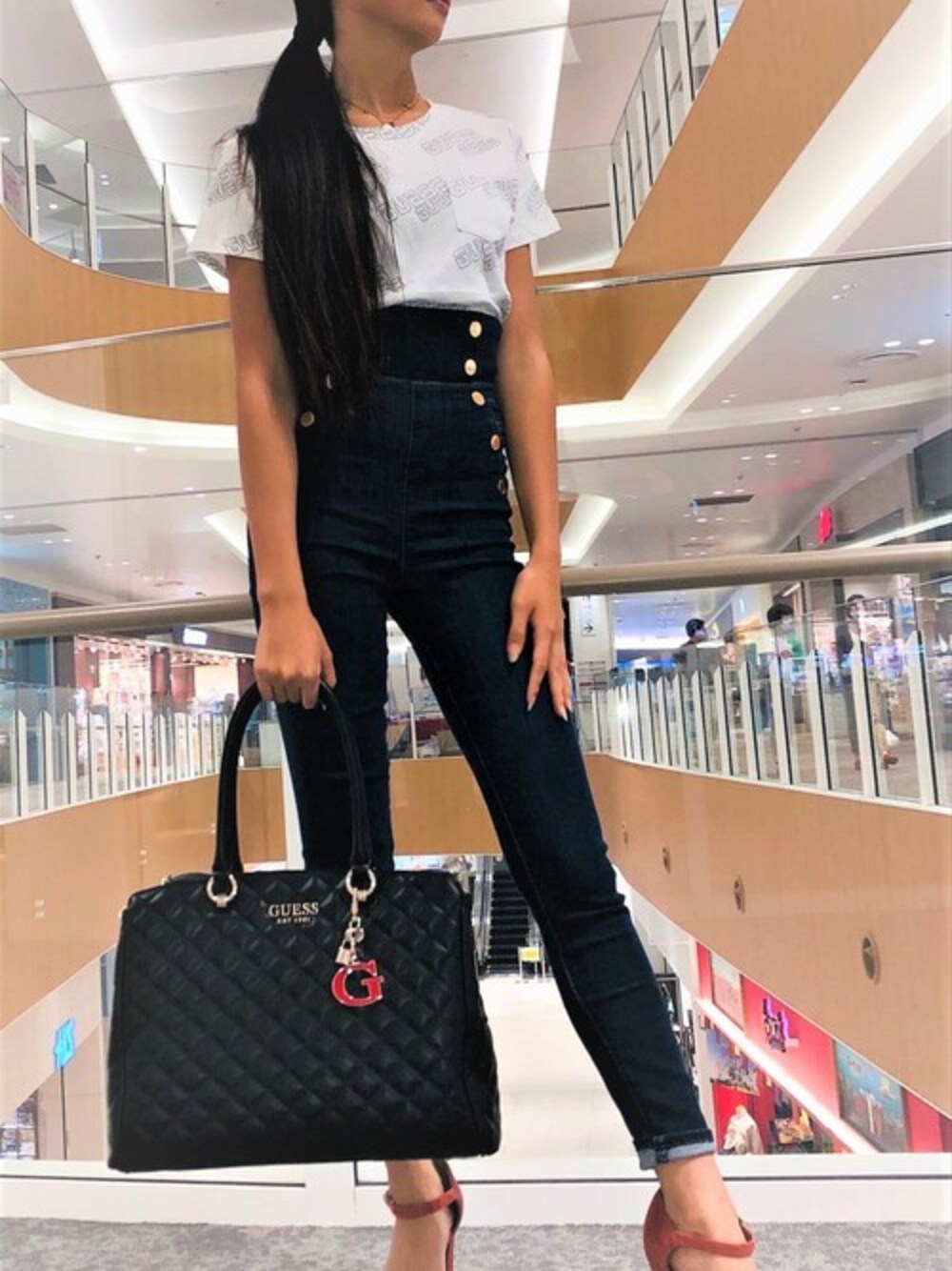 ブルー系のデニムパンツ、ブラック系のトートバッグを着用したレディースの秋コーディネートの1枚目の写真