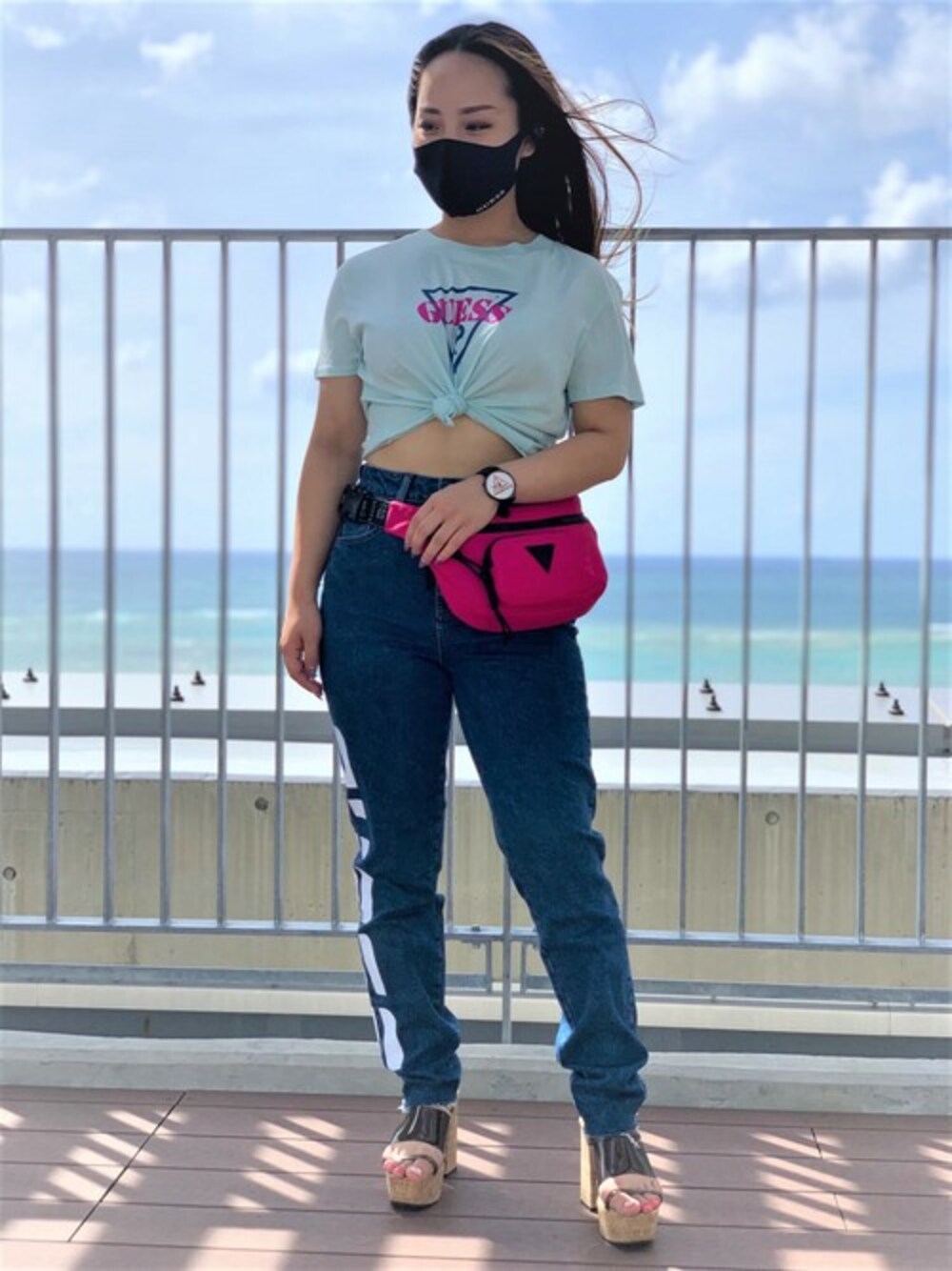 グリーン系のTシャツ/カットソー、ブルー系のデニムパンツ、ピンク系のボディバッグ/ウエストポーチを着用したレディースの秋コーディネートの1枚目の写真