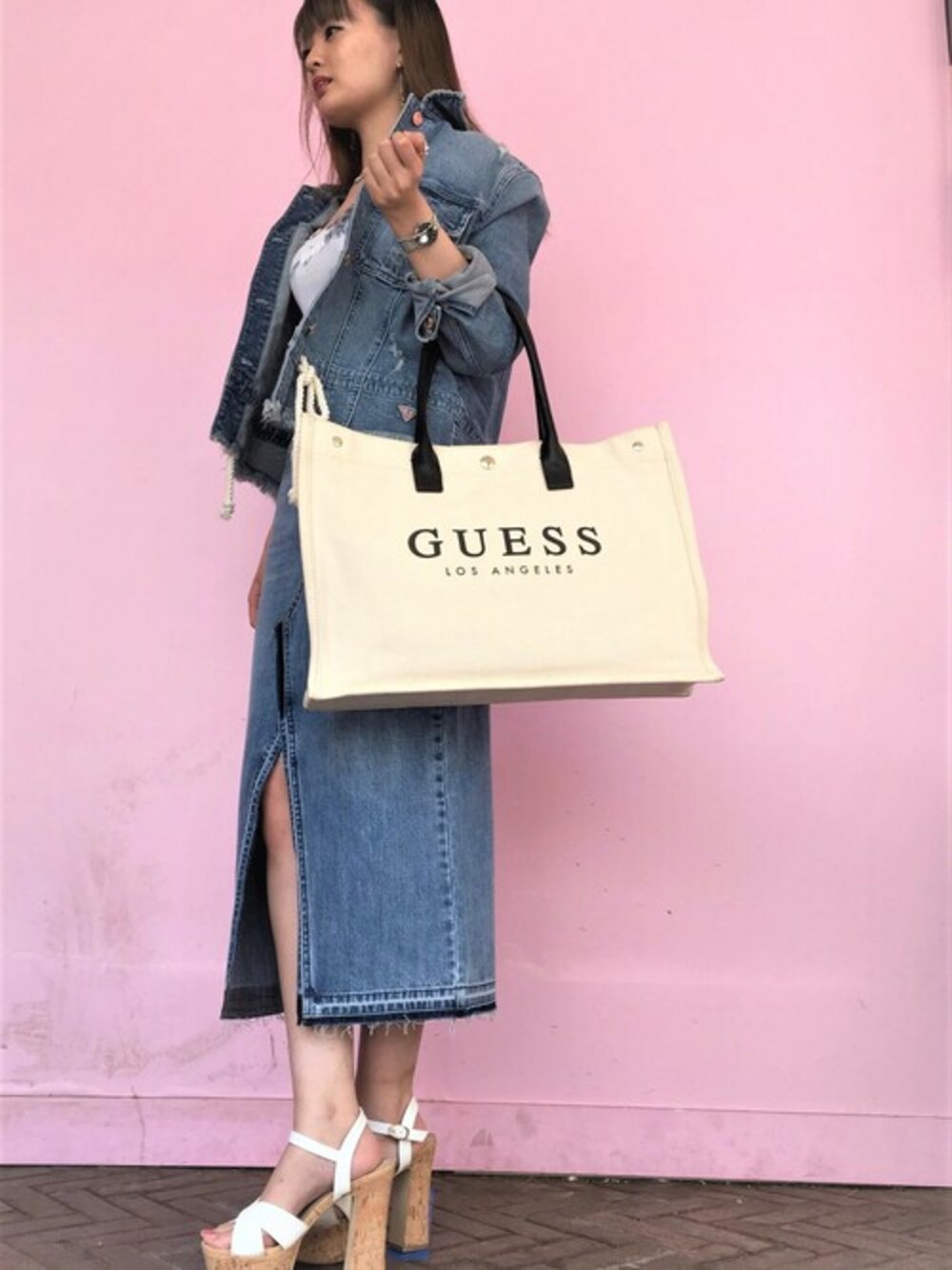 ブルー系のデニムジャケット、ブルー系のデニムスカート、ベージュ系のトートバッグを着用したレディースの秋コーディネートの1枚目の写真