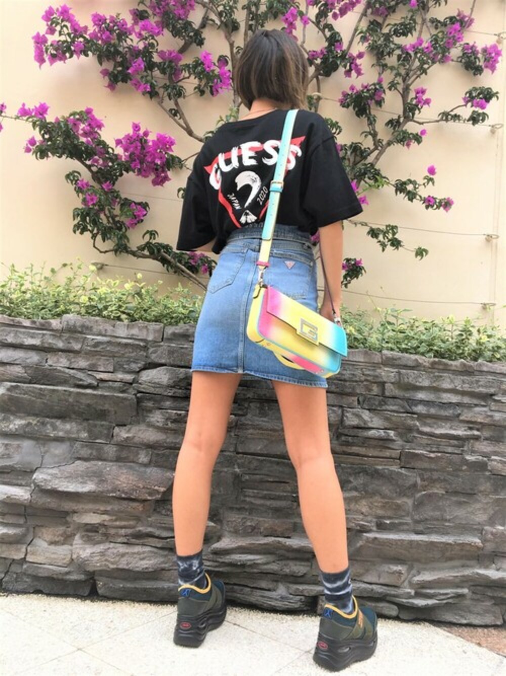 ブラック系のTシャツ/カットソー、ブルー系のデニムスカート、その他のショルダーバッグを着用したレディースの秋コーディネートの1枚目の写真