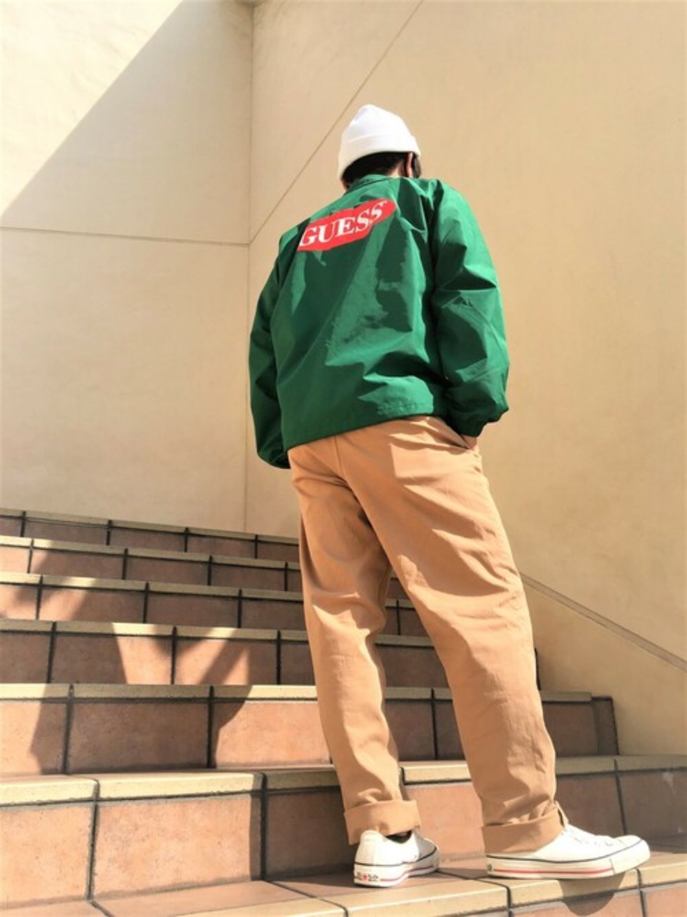 ホワイト系のTシャツ/カットソー、グリーン系のナイロンジャケット、ブラウン系のその他パンツを着用したメンズの秋コーディネートの1枚目の写真