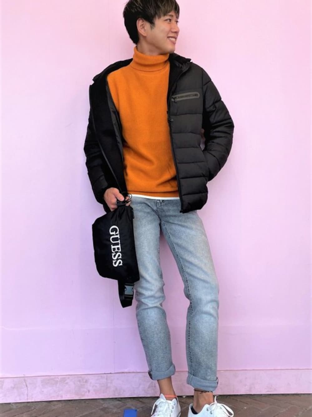 オレンジ系のニット/セーター、ブラック系のその他アウター、グレー系のデニムパンツを着用したメンズの秋コーディネートの1枚目の写真