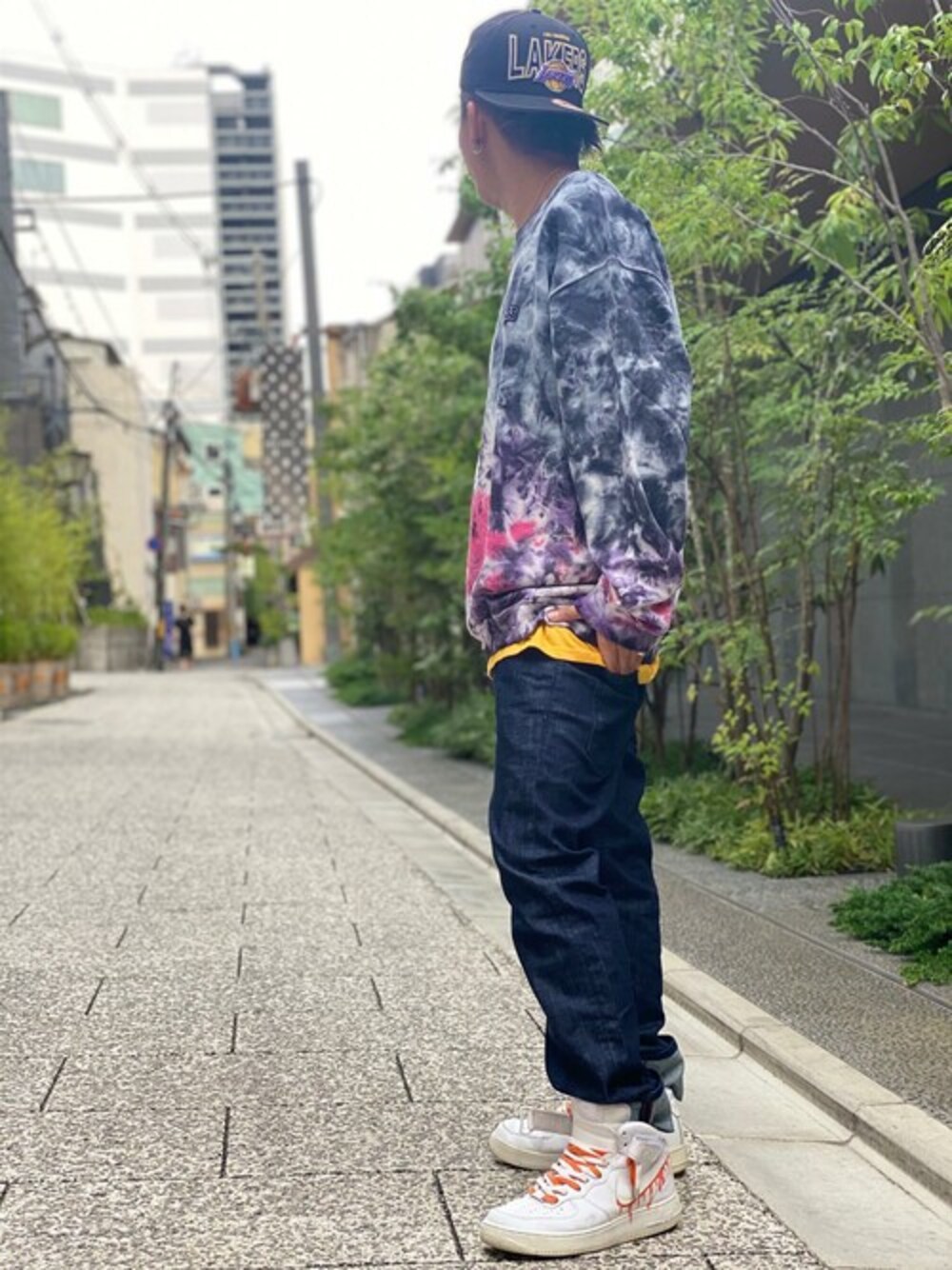 ブラック系のスウェット、イエロー系のTシャツ/カットソー、ブルー系のデニムパンツを着用したメンズの秋コーディネートの1枚目の写真