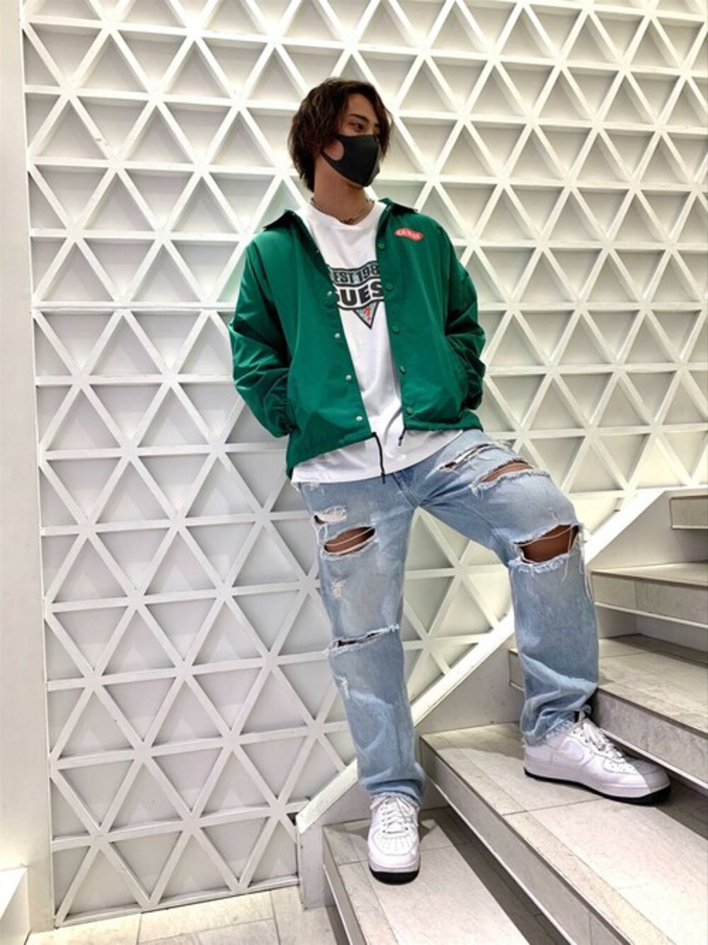 ホワイト系のTシャツ/カットソー、ブルー系のデニムパンツ、グリーン系のナイロンジャケットを着用したメンズの秋コーディネートの1枚目の写真