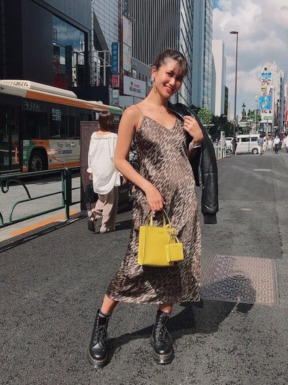 ブラウン系のワンピース、ブラック系のその他アウター、イエロー系のトートバッグを着用したレディースの秋コーディネートの1枚目の写真