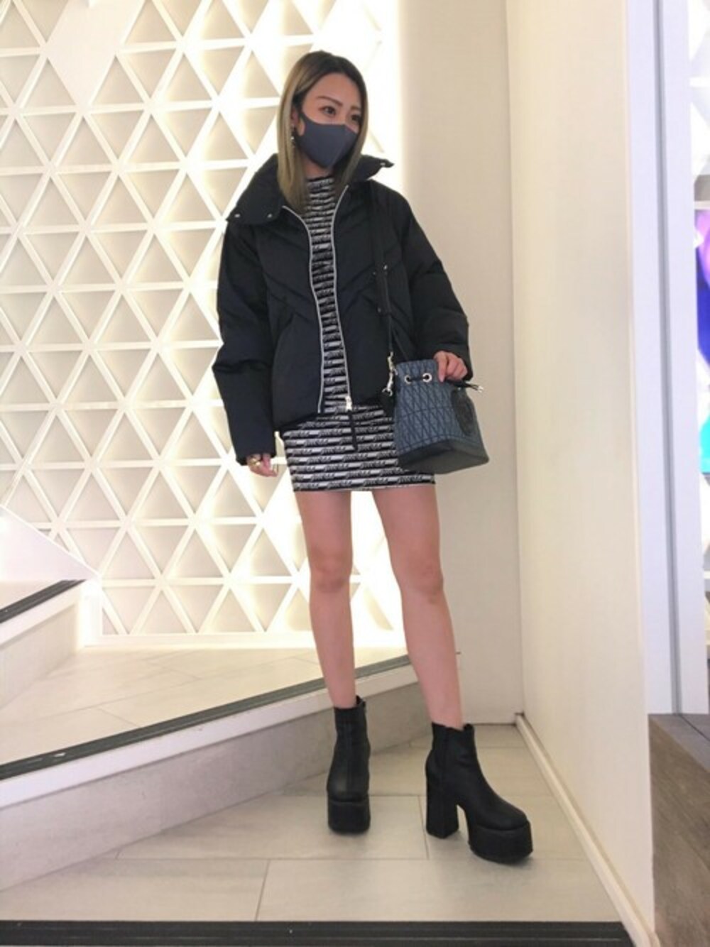 ブラック系のワンピース、ブラック系のその他アウター、ブルー系のショルダーバッグを着用したレディースの秋コーディネートの1枚目の写真