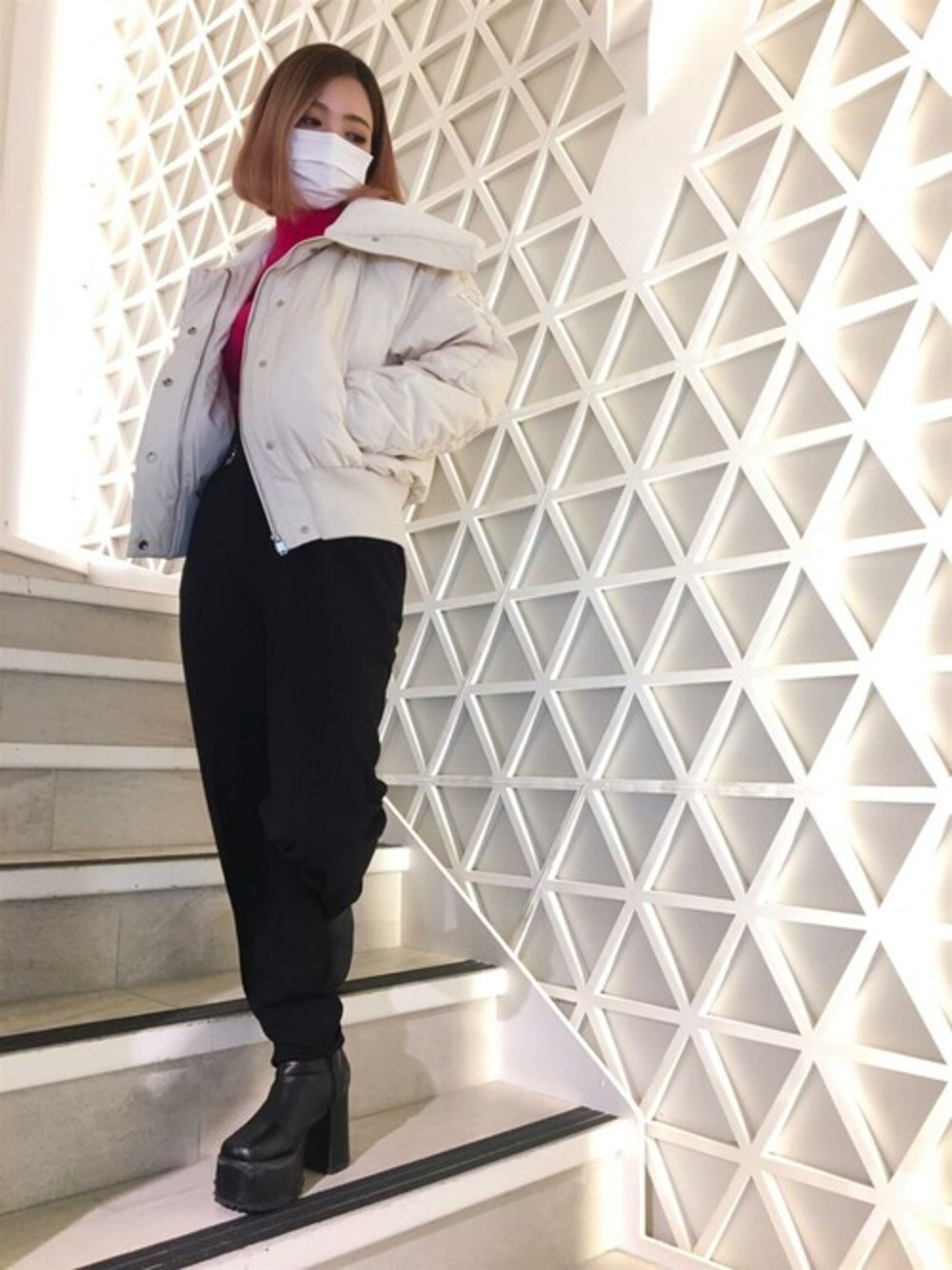 ピンク系のニット/セーター、ホワイト系のダウンジャケット/コート、ブラック系のその他パンツを着用したレディースの冬コーディネートの1枚目の写真