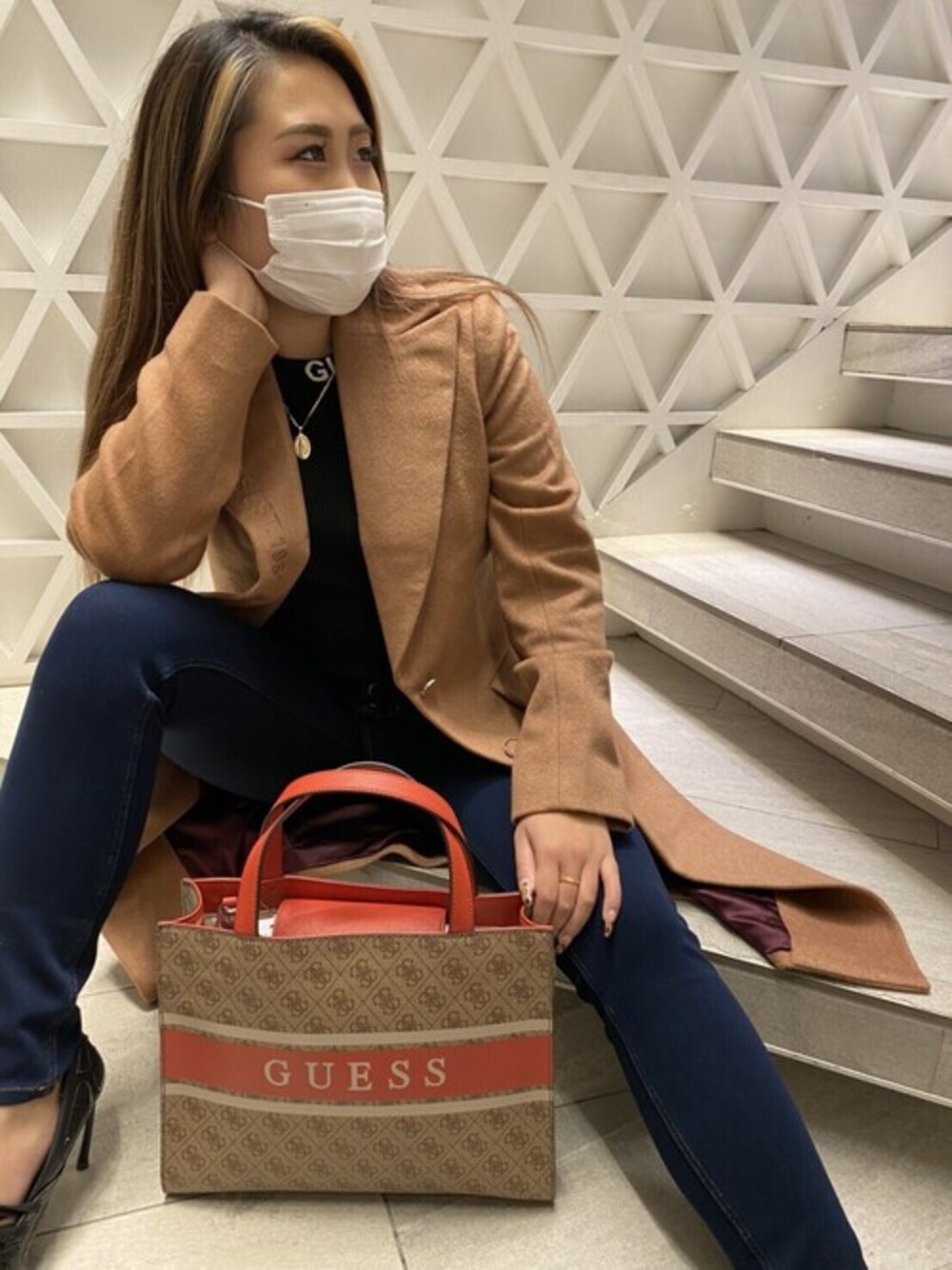 「トートバッグ、ハイウエスト、ロングコート、キャメルアウター、スキニーデニム、guess、ゲス、ワンショルダー、モノグラム、ボタンフライ」｜「GuessのSoraya Cut-Out Sweater（ニット/セーター、ブラック系）」を使った、GUESS JAPANさん（レディース・154cm）の冬コーディネートの1枚目の写真