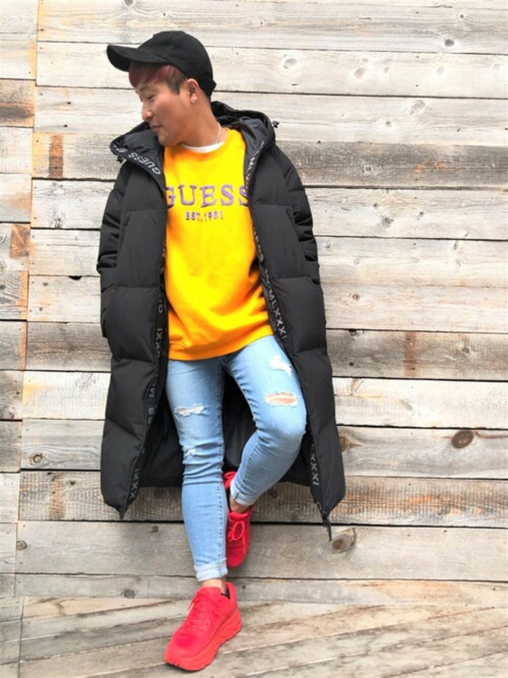 イエロー系のスウェット、ブルー系のデニムパンツを着用したメンズの冬コーディネートの1枚目の写真