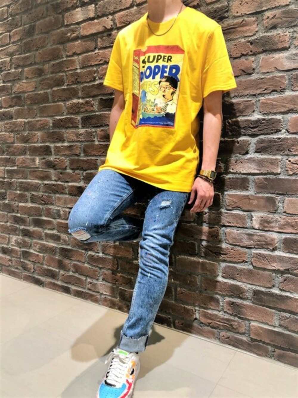 イエロー系のTシャツ/カットソー、ブルー系のデニムパンツを着用したメンズの冬コーディネートの1枚目の写真
