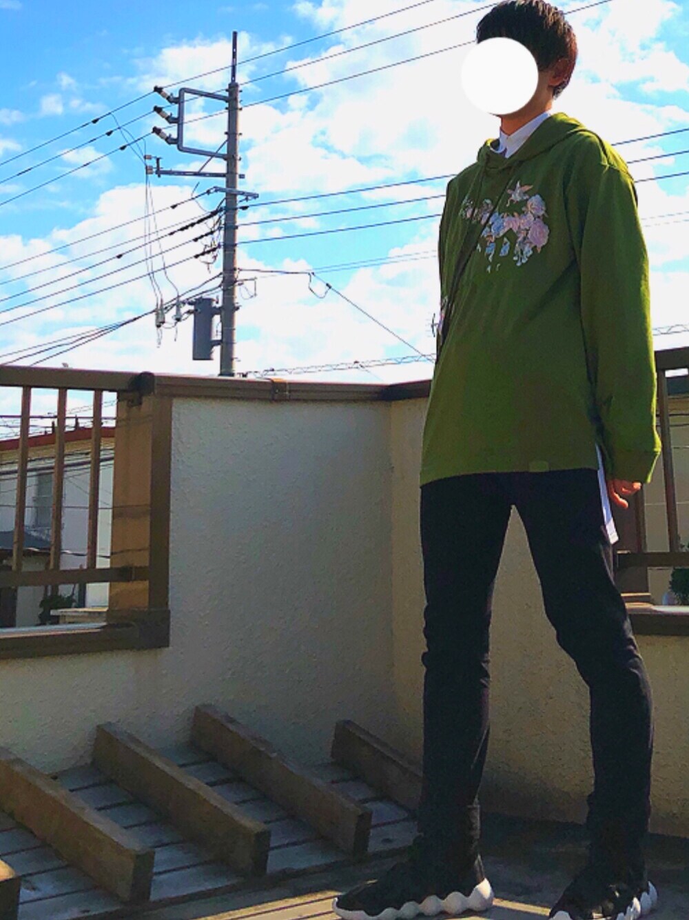 ブラック系のスニーカー、ブラック系のデニムパンツ、グリーン系のパーカーを着用したメンズの秋コーディネートの1枚目の写真