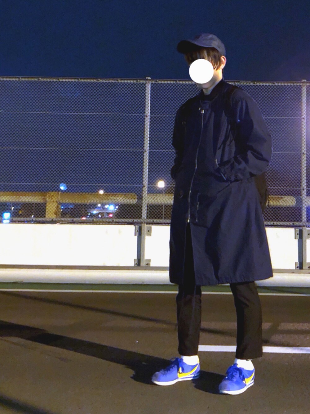 ブルー系のスニーカー、ブラック系のパンツ、ブルー系のモッズコートを着用したメンズの秋コーディネートの1枚目の写真