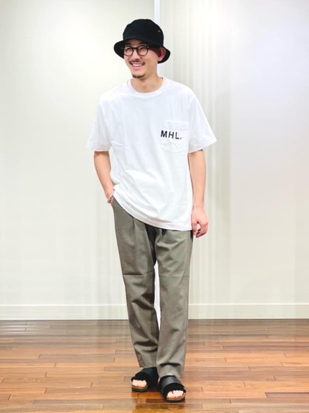 ブラック系のサンダル、グリーン系のその他パンツ、ホワイト系のTシャツ/カットソーを着用したメンズの春コーディネートの1枚目の写真