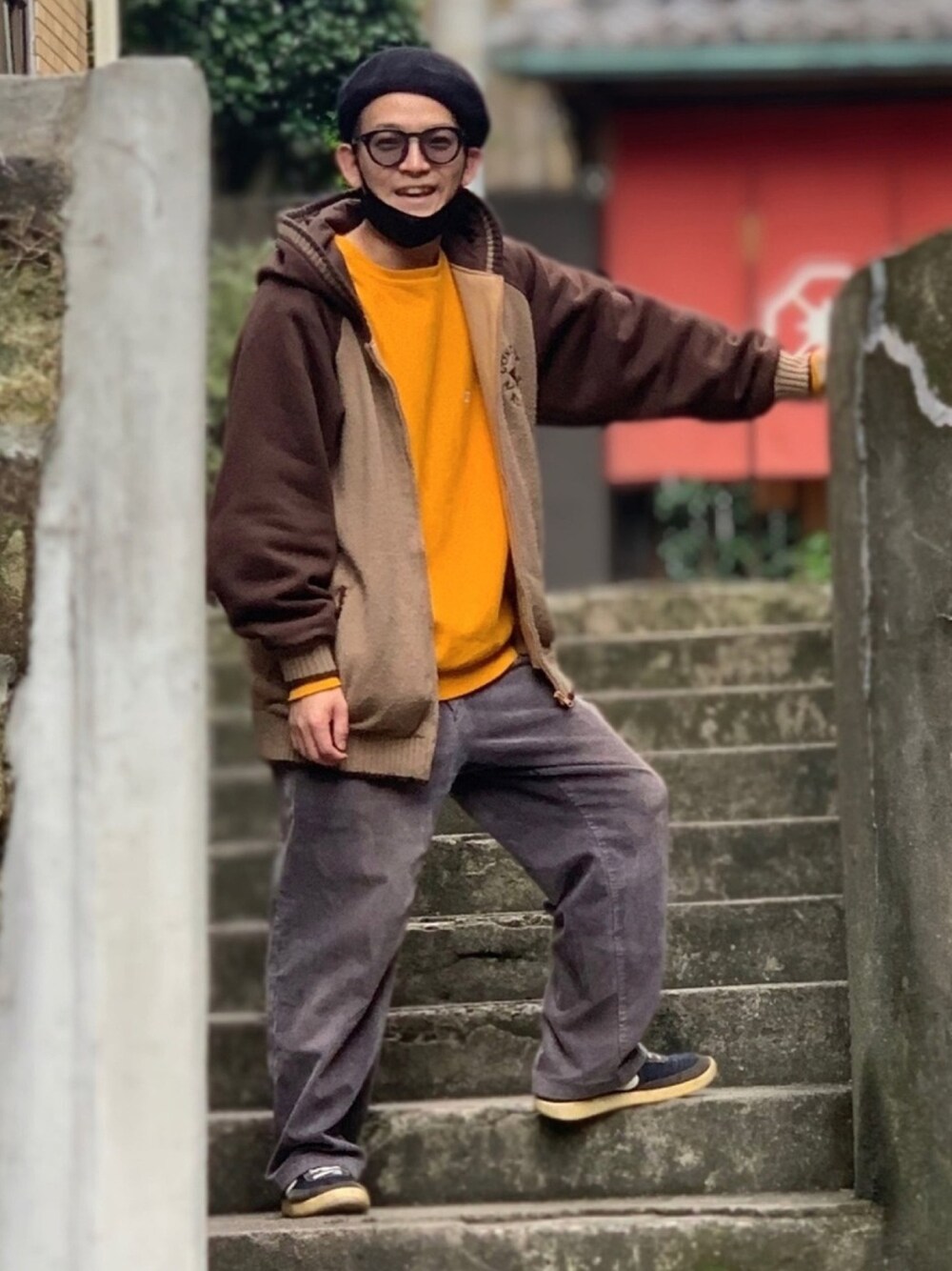 ブラウン系のパーカー、イエロー系のスウェット、ブラック系のスニーカーを着用したメンズの冬コーディネートの1枚目の写真