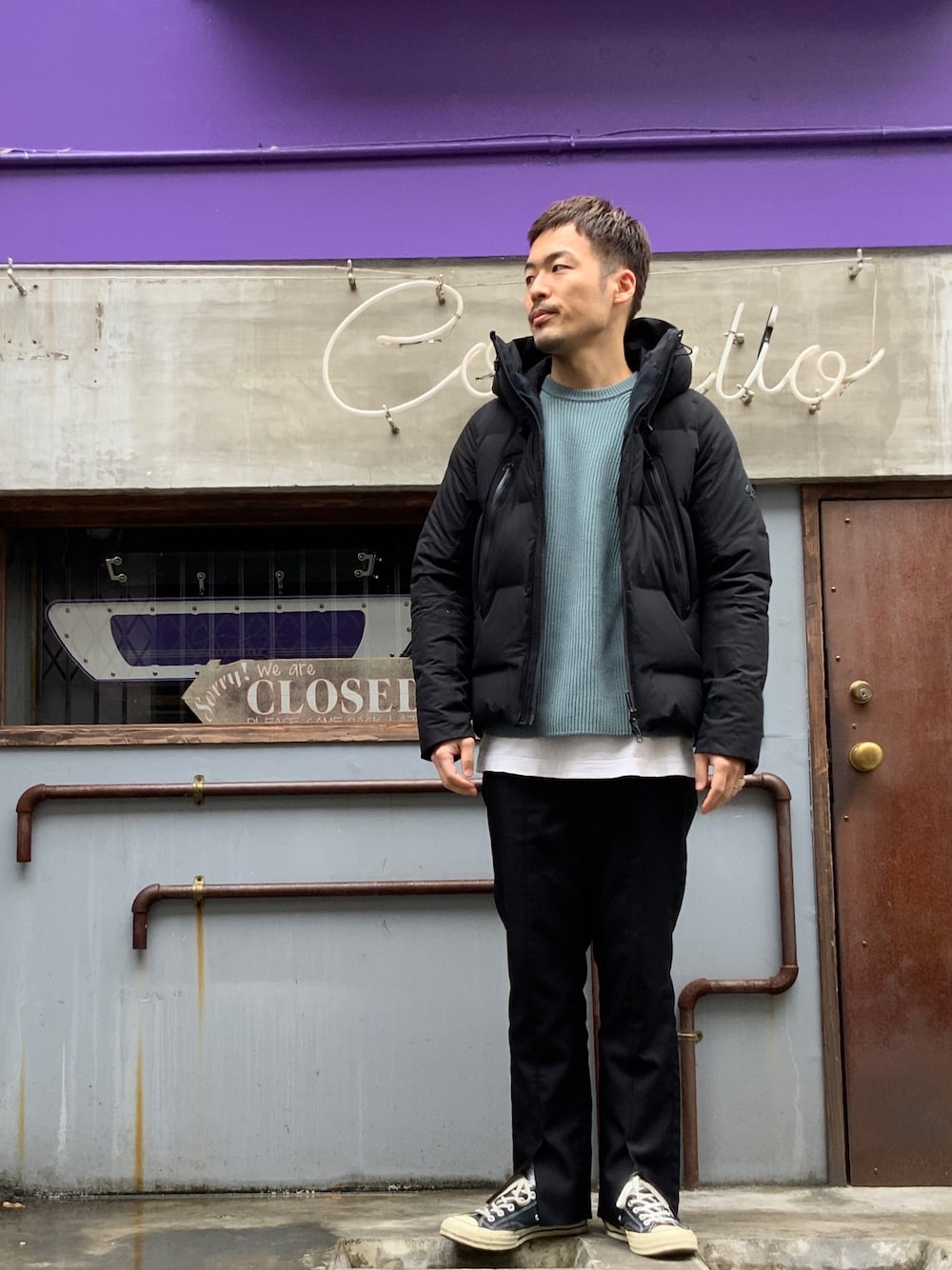 ホワイト系のダウンジャケット/コート、ブルー系のニット/セーター、ホワイト系のTシャツ/カットソーを着用したメンズの冬コーディネートの1枚目の写真