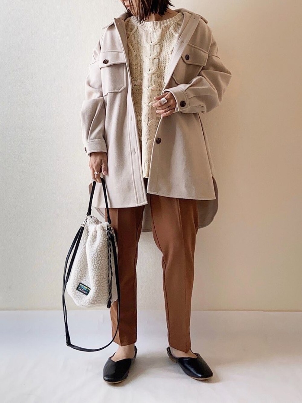 イエロー系のその他パンツ、ベージュ系のカバーオールを着用したレディースの冬コーディネートの1枚目の写真