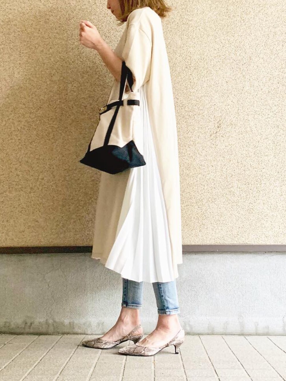 ベージュ系のワンピース/ドレス、ホワイト系のトートバッグ、ブルー系のデニムパンツを着用したレディースの春コーディネートの1枚目の写真