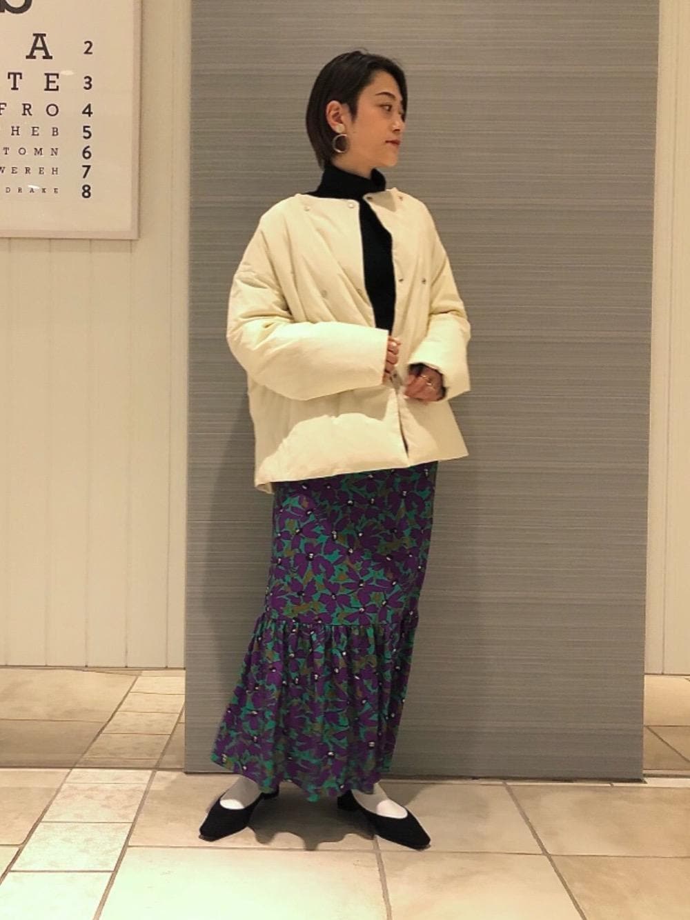 ブラック系のパンプス、ベージュ系のダウンジャケット/コート、ブラック系のニット/セーターを着用したレディースの冬コーディネートの1枚目の写真