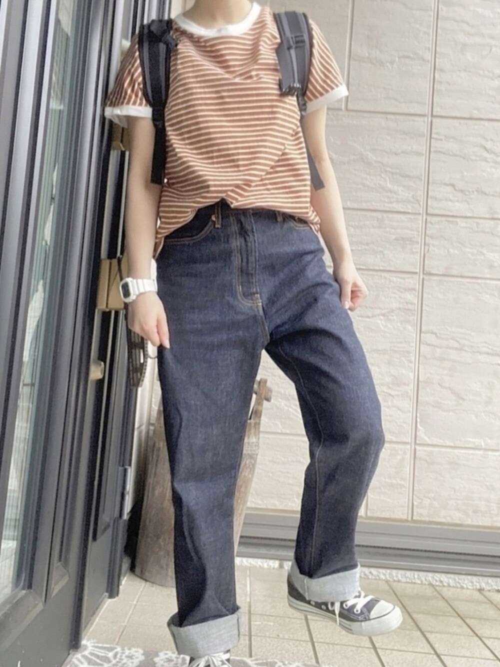オレンジ系のTシャツ/カットソー、ブルー系のデニムパンツ、ブラック系のスニーカーを着用したレディースの夏コーディネートの1枚目の写真