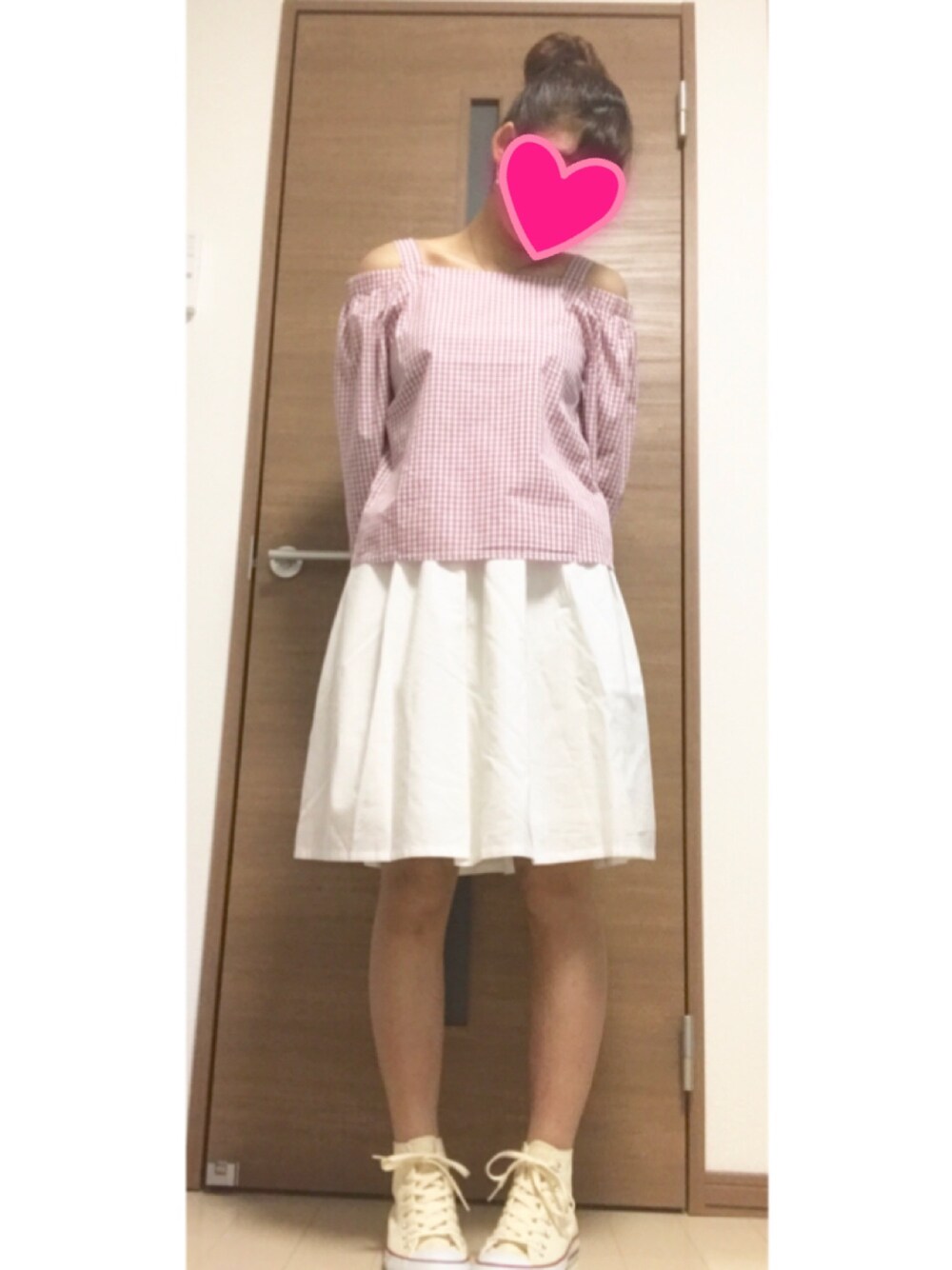 ピンク系のトップス、ホワイト系のスカート、ホワイト系のスニーカーを着用したレディースの春コーディネートの1枚目の写真
