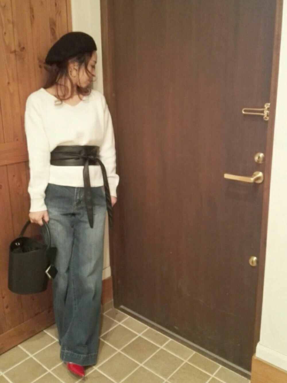 ブルー系のデニムパンツ、ホワイト系のニット/セーター、ブラック系のショルダーバッグを着用したレディースの春コーディネートの1枚目の写真