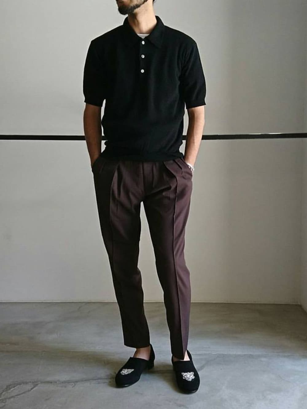 ブラック系のポロシャツ、パープル系のスラックス、ブラック系のスリッポンを着用したメンズの夏コーディネートの1枚目の写真