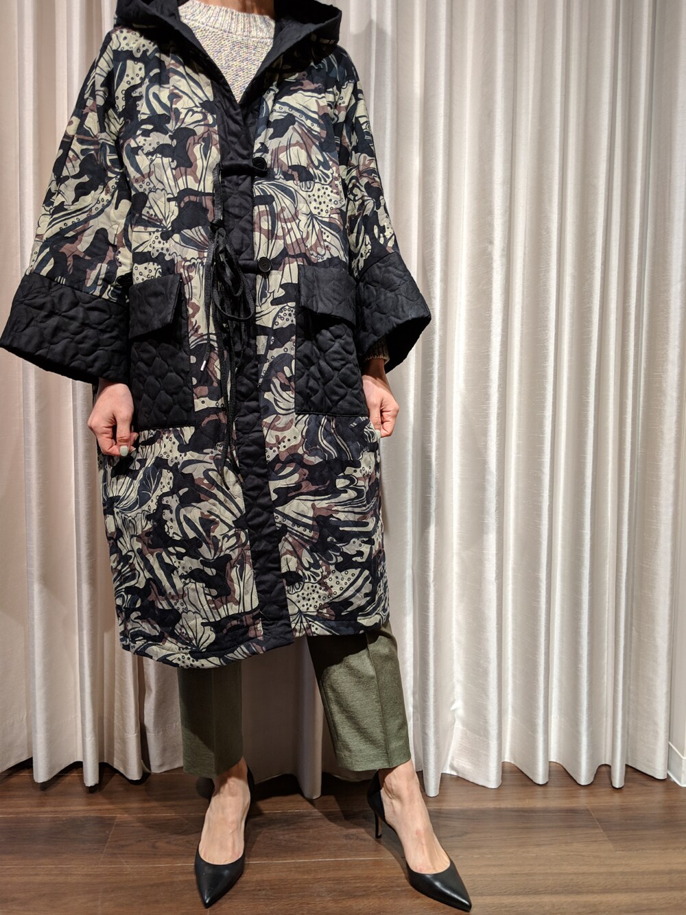 グリーン系のジャケット/アウター、グリーン系のスラックス、ベージュ系のニット/セーターを着用したレディースの冬コーディネートの1枚目の写真