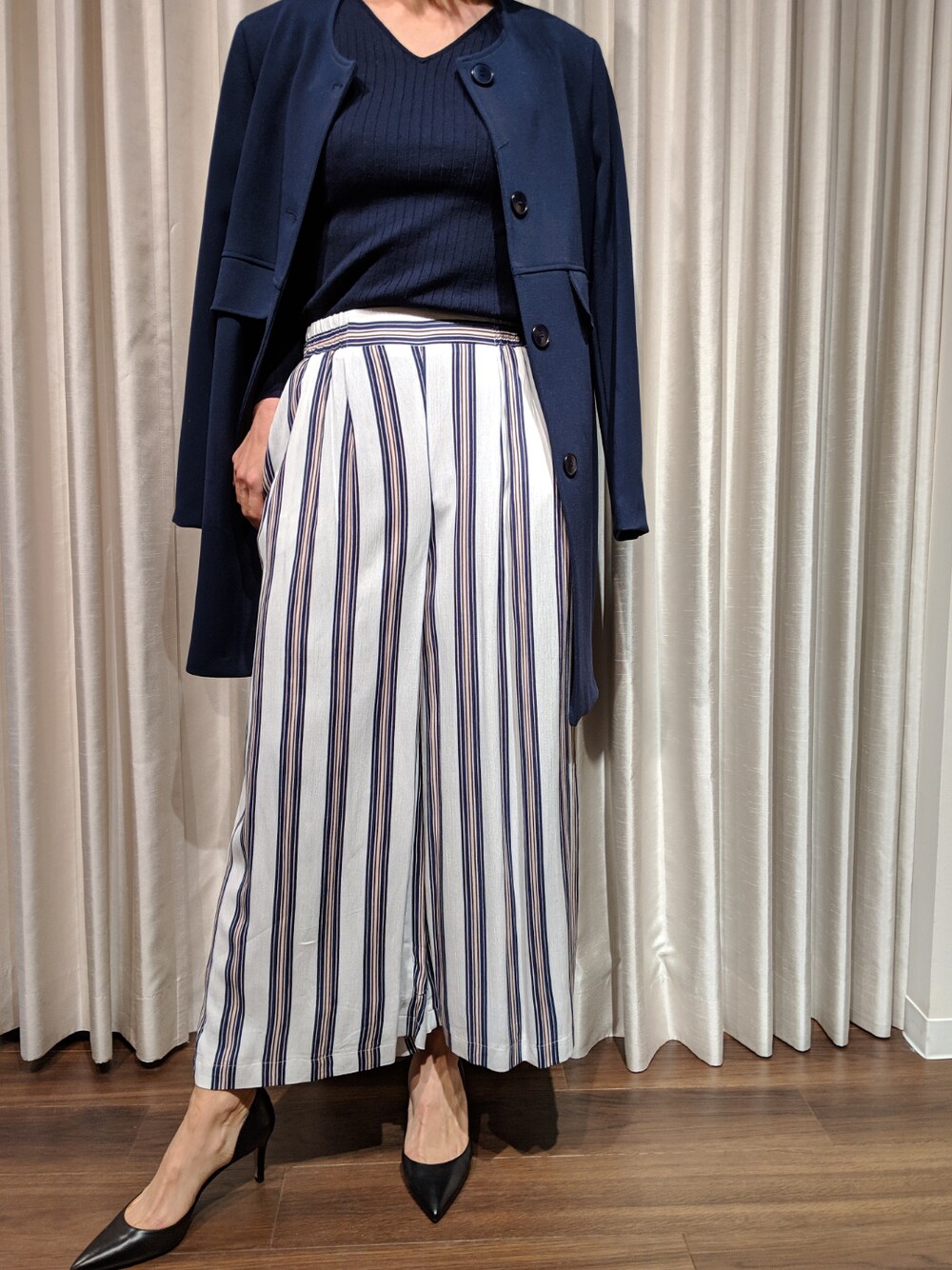 ホワイト系のパンツ、ブルー系のノーカラージャケット、ブルー系のニット/セーターを着用したレディースの冬コーディネートの1枚目の写真