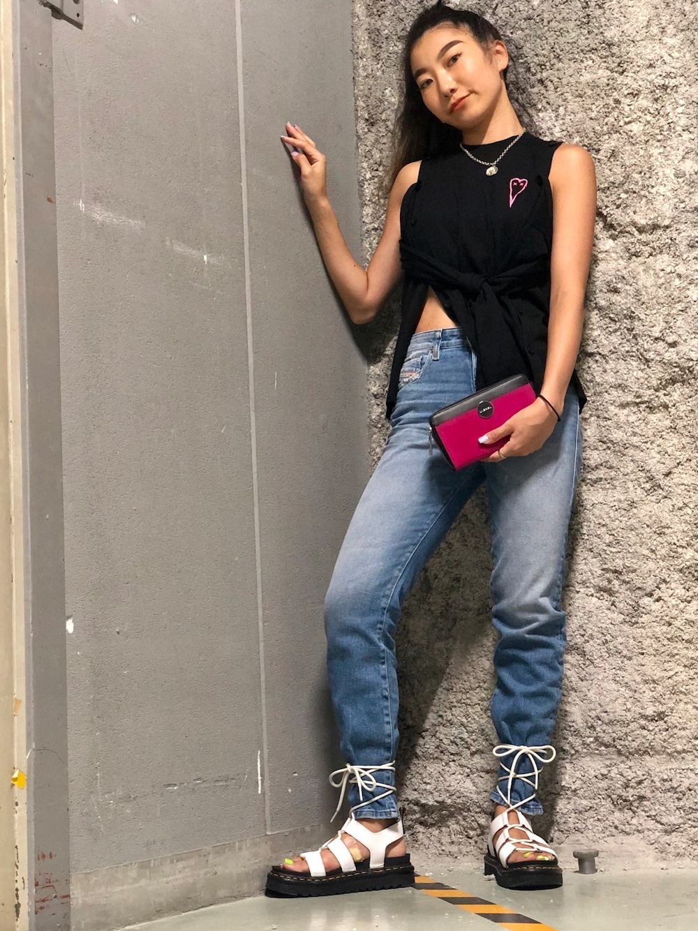 ブラック系のニット/セーター、ブルー系のデニムパンツ、ホワイト系のサンダルを着用したレディースの夏コーディネートの1枚目の写真