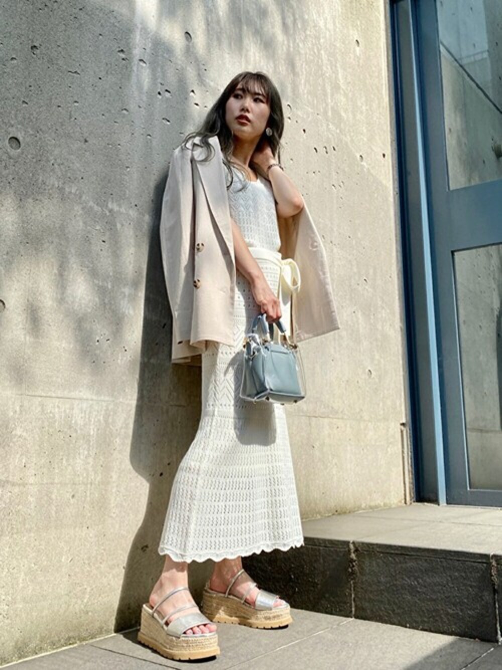 ベージュ系のワンピース、ホワイト系のワンピース、ブルー系のショルダーバッグを着用したレディースの夏コーディネートの1枚目の写真