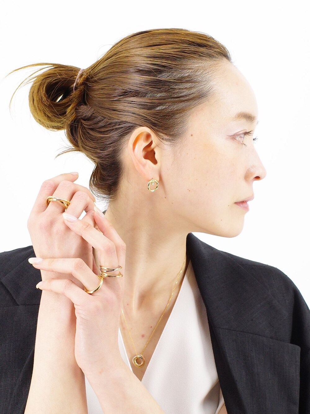 ブラック系のジャケット/アウター、ゴールド系のピアス（片耳用）、ゴールド系のネックレスを着用したレディースの春コーディネートの1枚目の写真