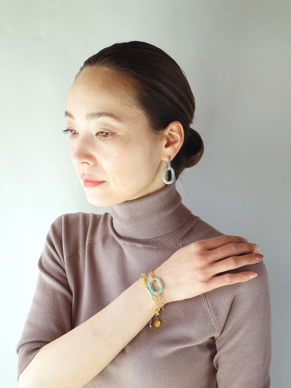 ブルー系のピアス（両耳用）、ブルー系のブレスレット、ゴールド系のブレスレットを着用したレディースの冬コーディネートの1枚目の写真