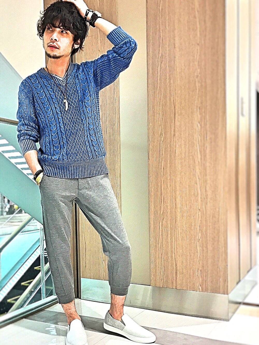 ブルー系のニット/セーター、グレー系のその他パンツ、ホワイト系のスリッポンを着用したメンズの春コーディネートの1枚目の写真