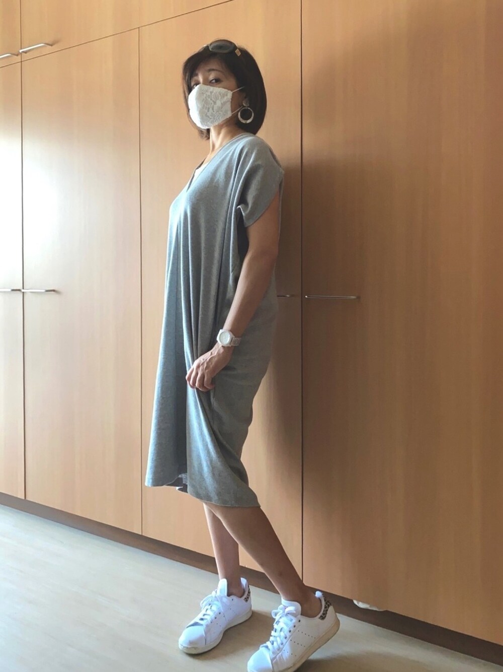 グレー系のワンピース、ホワイト系のスニーカー、ブラウン系のサングラスを着用したレディースの夏コーディネートの1枚目の写真