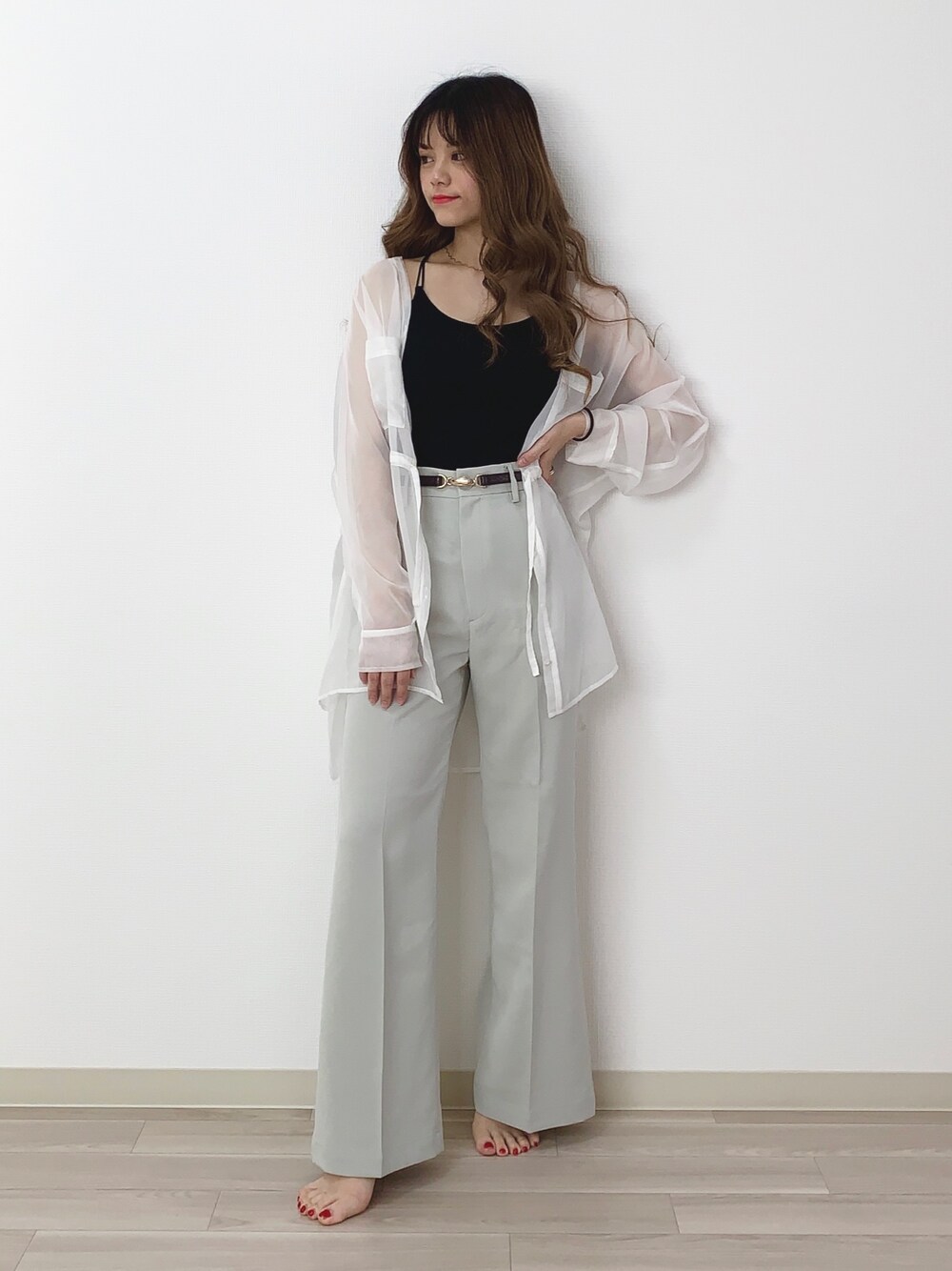 ブラック系のキャミソール、ホワイト系のシャツ/ブラウス、グリーン系のスラックスを着用したレディースの春コーディネートの1枚目の写真