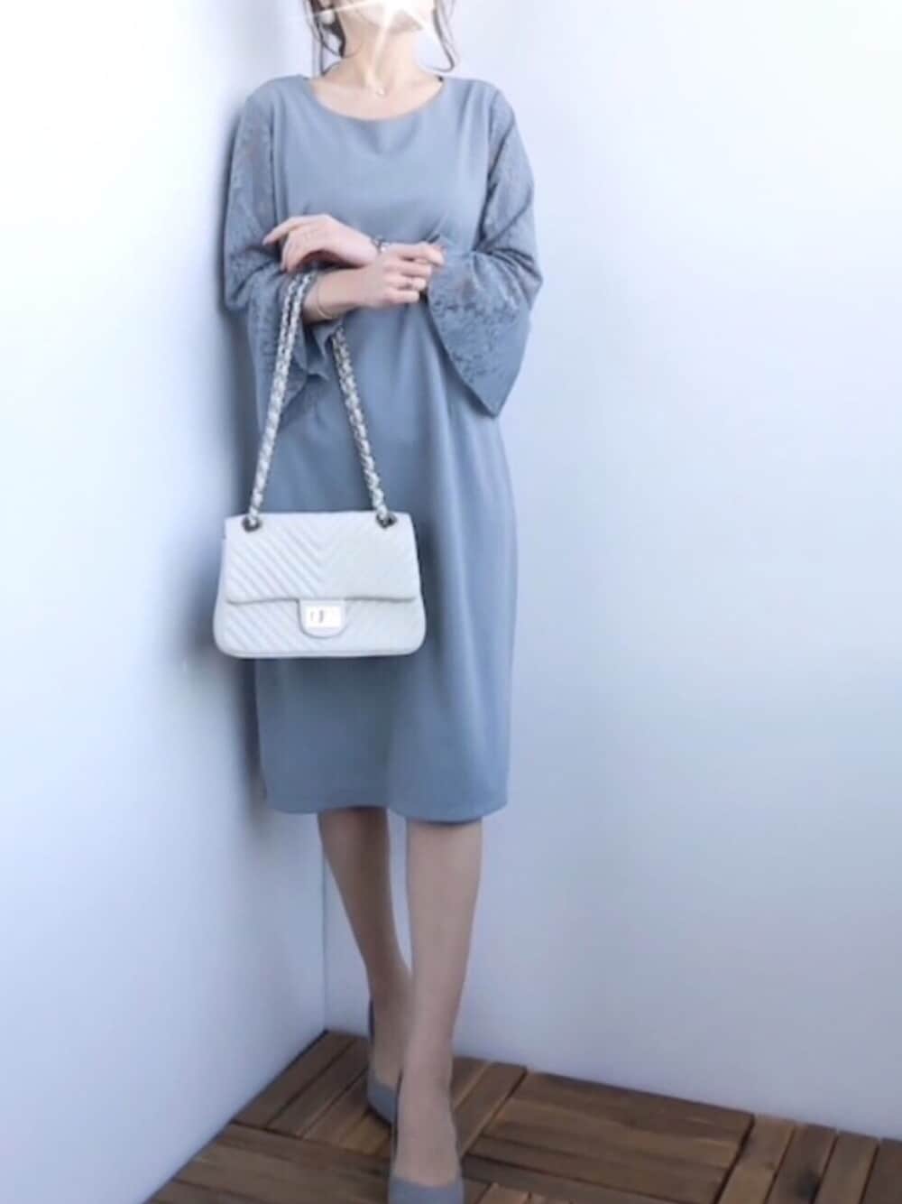 グレー系のドレス、ホワイト系のショルダーバッグを着用したレディースの春コーディネートの1枚目の写真