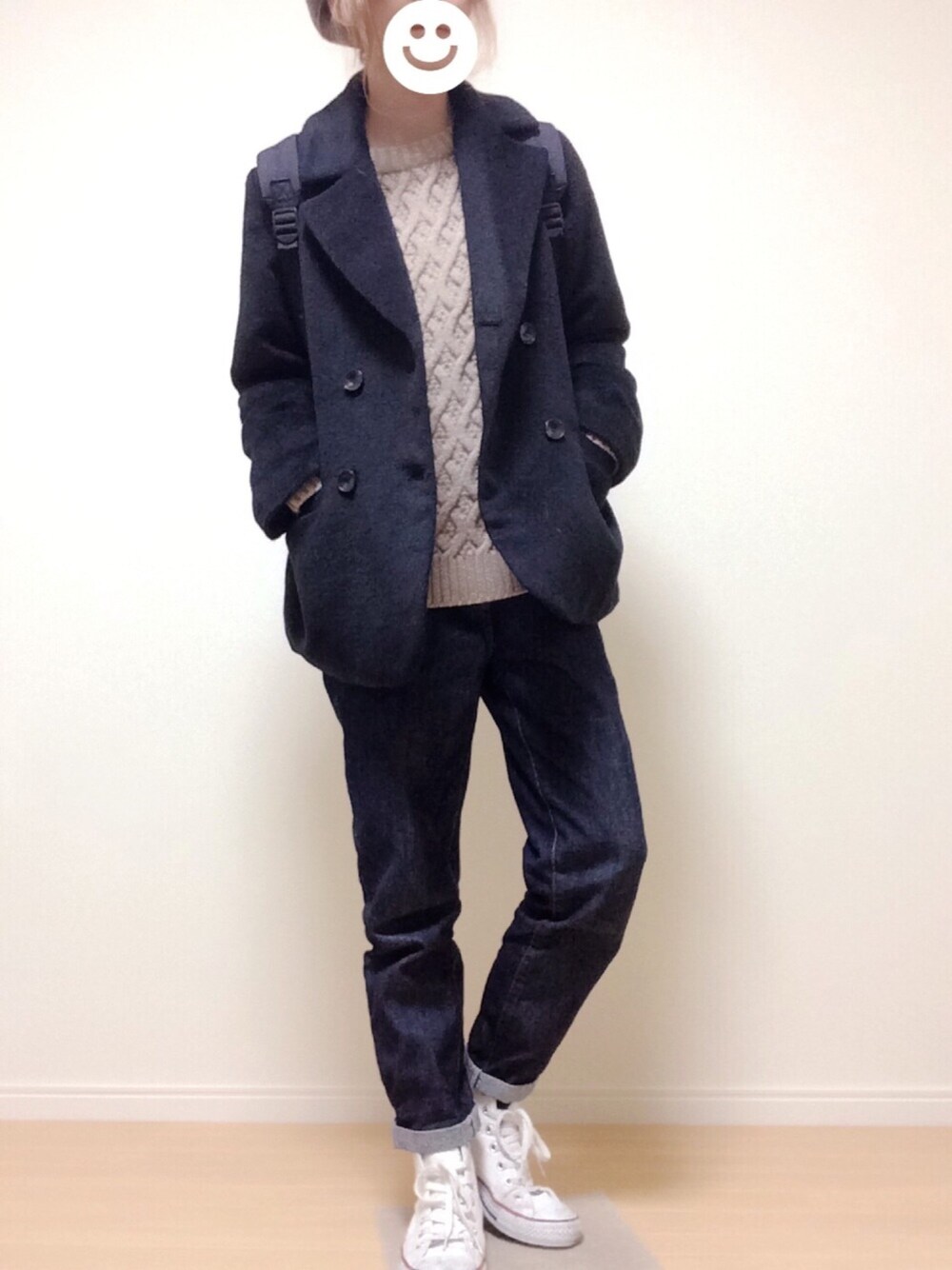 ブラック系のジャケット/アウター、ベージュ系のニット/セーター、ブルー系のデニムパンツを着用したレディースの冬コーディネートの1枚目の写真