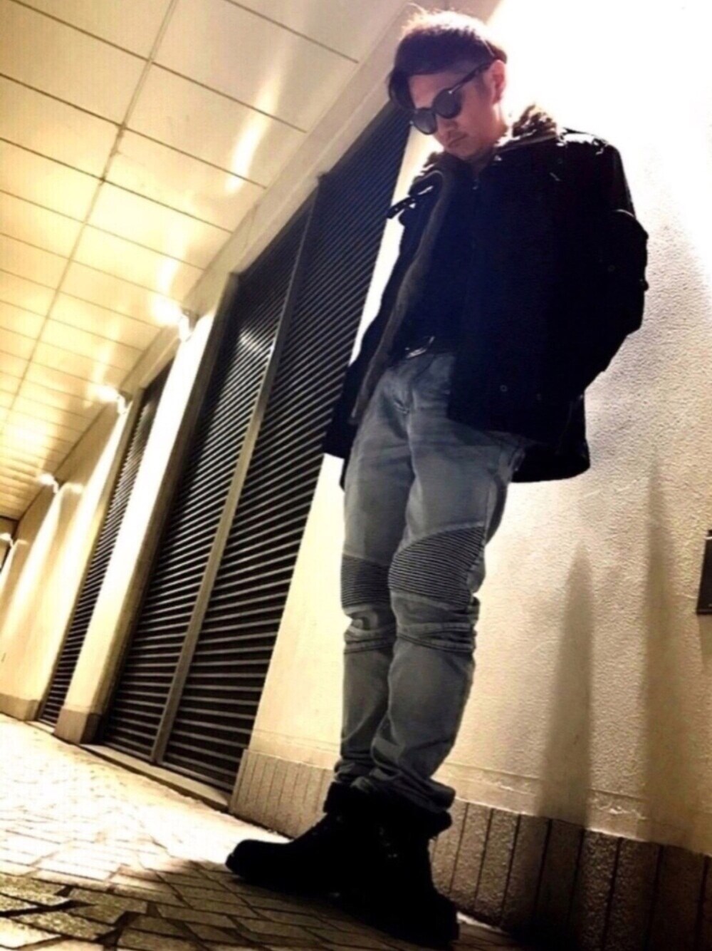 ブルー系のデニムパンツ、ブラック系のブーツ、ブラック系のTシャツ/カットソーを着用したメンズの冬コーディネートの1枚目の写真
