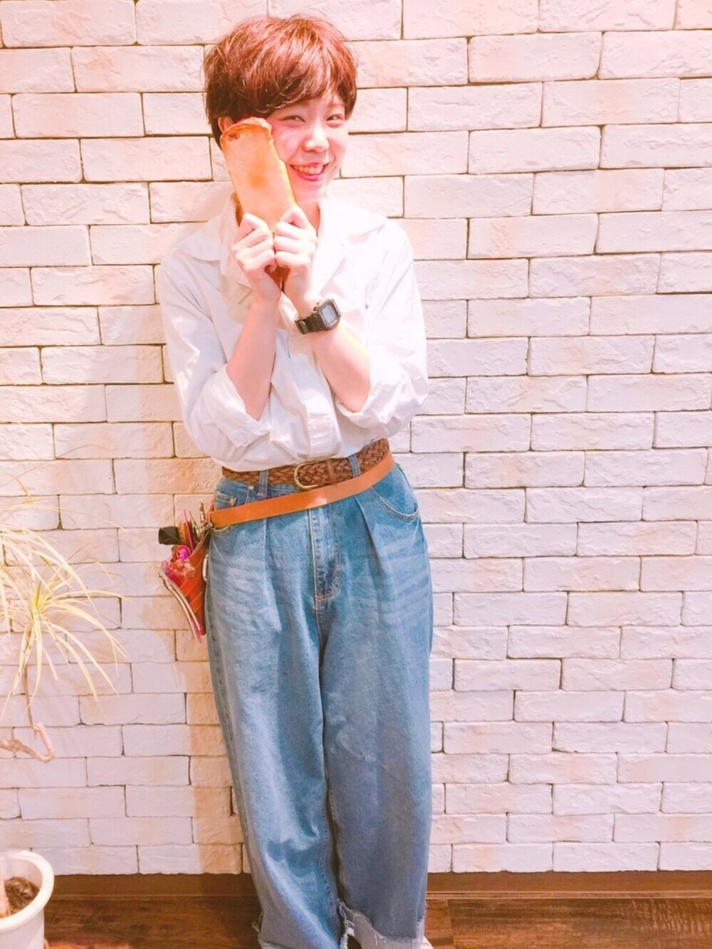 ホワイト系のスニーカー、ブルー系のデニムパンツ、ブラック系のアナログ腕時計を着用したレディースの冬コーディネートの1枚目の写真