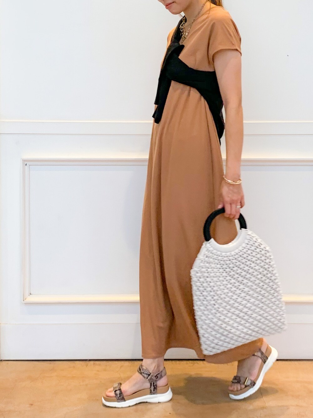 イエロー系のワンピース、ブラック系のカーディガン/ボレロ、ホワイト系のトートバッグを着用したレディースの夏コーディネートの1枚目の写真