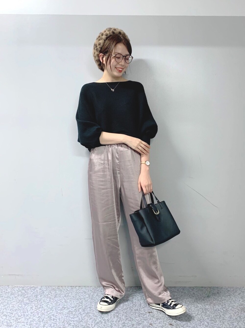 シルバー系のパンツ、ブラック系のニット/セーター、ブラウン系のハンチング/ベレー帽を着用したレディースの秋コーディネートの1枚目の写真
