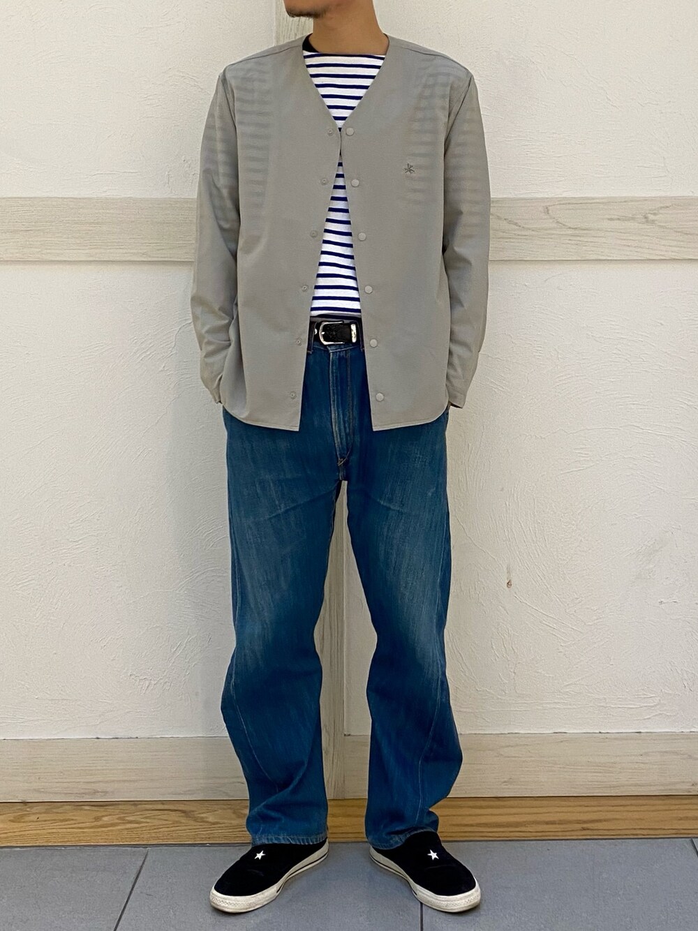 グレー系のカーディガン/ボレロ、ブルー系のデニムパンツ、ブラック系のローファーを着用したメンズの春コーディネートの1枚目の写真