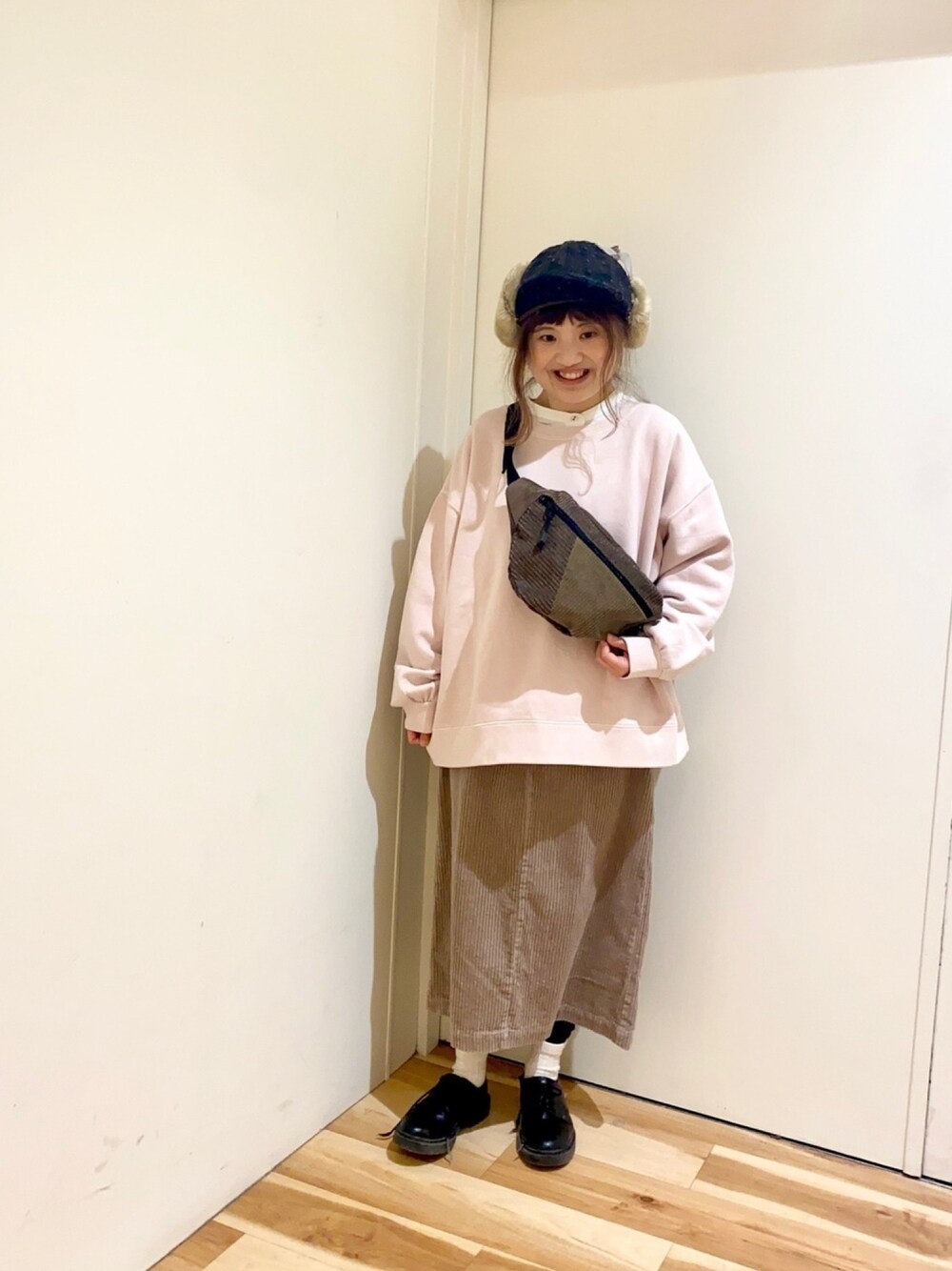 ピンク系のTシャツ/カットソー、ベージュ系のスカート、ホワイト系のシャツ/ブラウスを着用したレディースの冬コーディネートの1枚目の写真