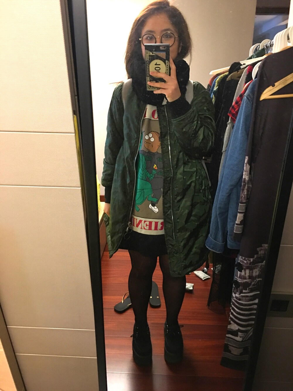 グリーン系のカバーオール、ブラック系のブーツを着用したレディースの冬コーディネートの1枚目の写真