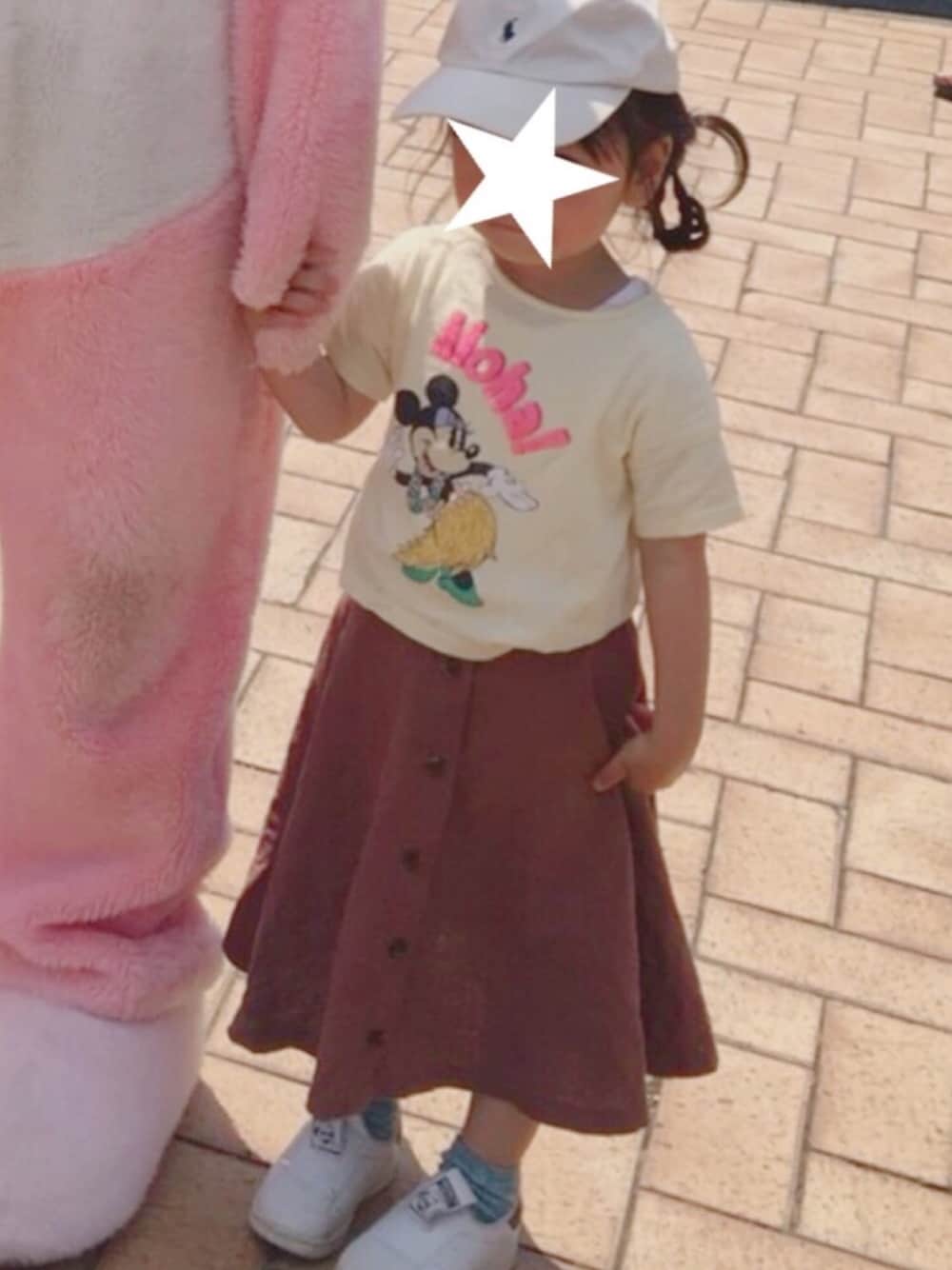 イエロー系のTシャツ/カットソー、ブラウン系のスカート、ホワイト系のスニーカーを着用したキッズの冬コーディネートの1枚目の写真