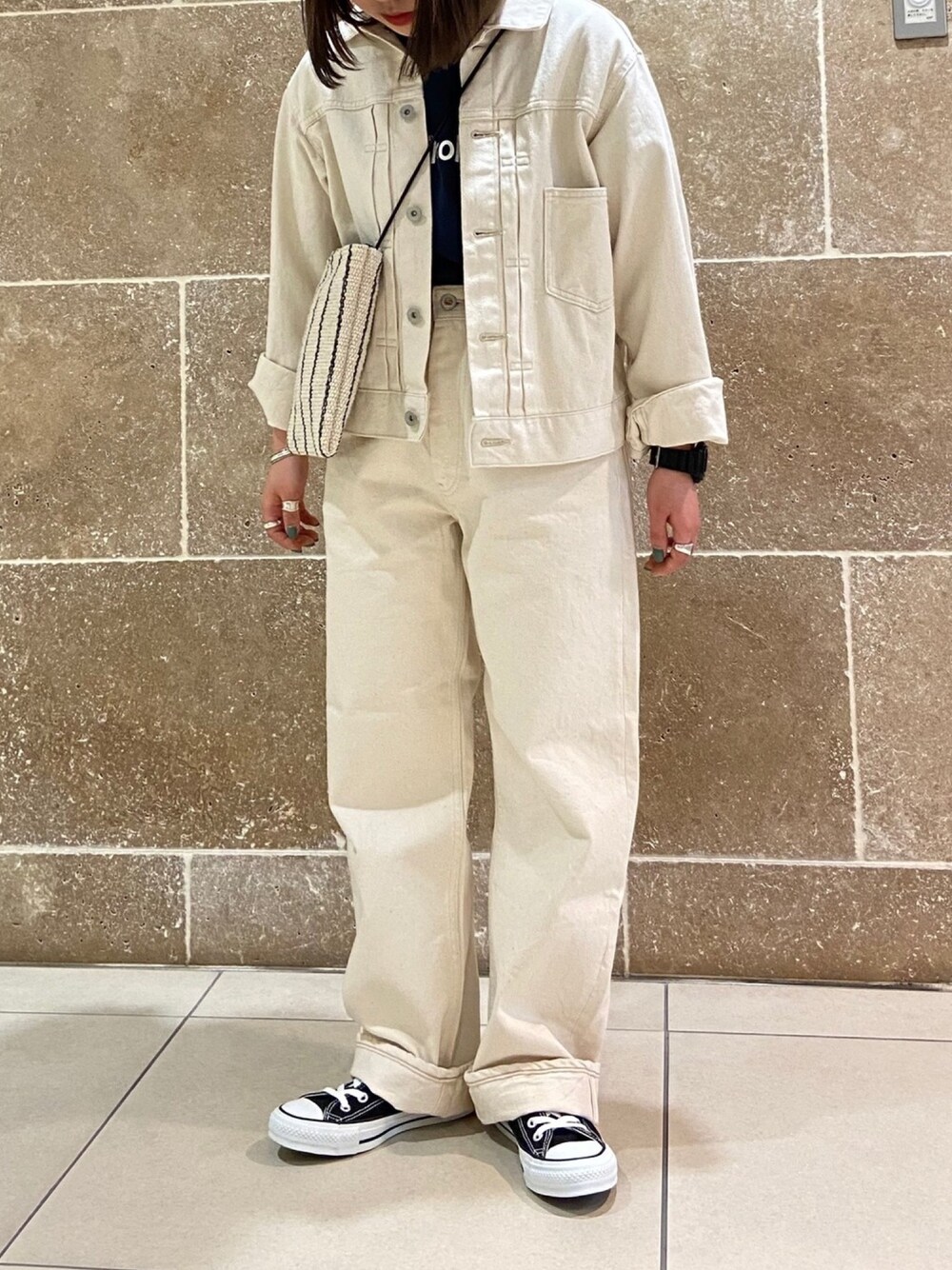 ベージュ系のデニムジャケット、ブルー系のTシャツ/カットソー、ホワイト系のパンツを着用したレディースの春コーディネートの1枚目の写真