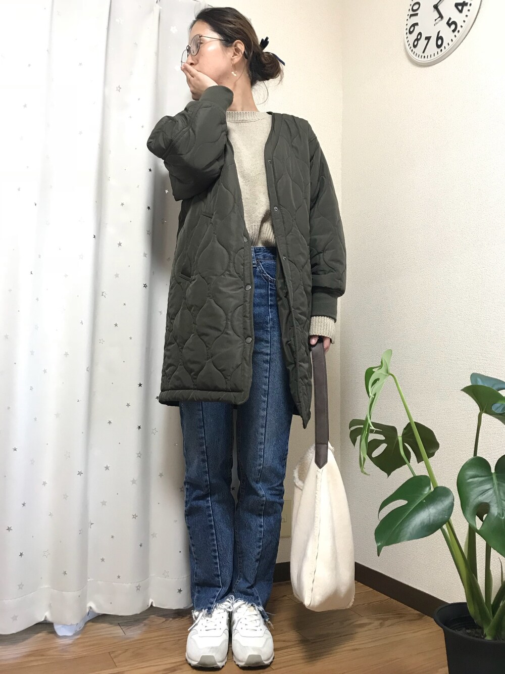 ブルー系のデニムパンツ、グリーン系のジャケット/アウター、ベージュ系のニット/セーターを着用したレディースの春コーディネートの1枚目の写真