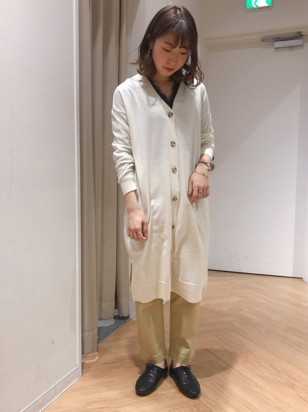 ホワイト系のカーディガン/ボレロ、ベージュ系のその他パンツ、ブラック系のTシャツ/カットソーを着用したレディースの冬コーディネートの1枚目の写真