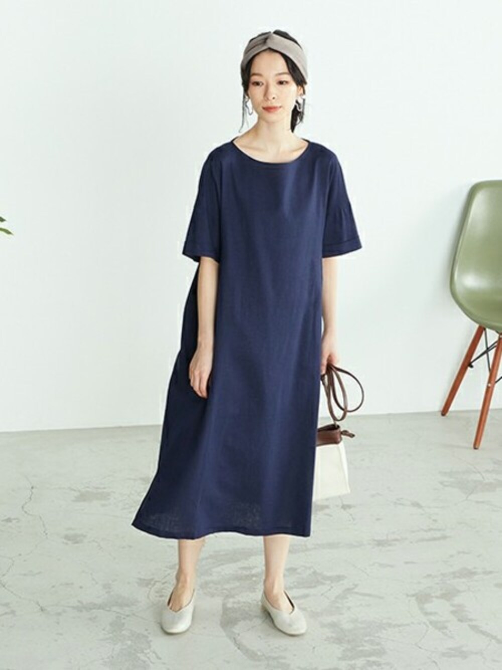 ブルー系のワンピース、ホワイト系のパンプス、ホワイト系のショルダーバッグを着用したレディースの春コーディネートの1枚目の写真